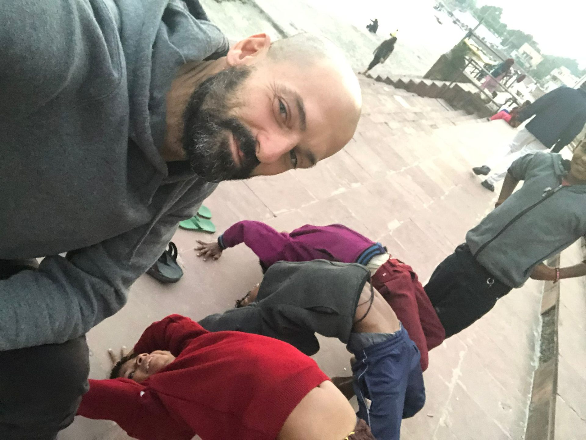 Ignacio ajustando a niños practicando yoga en India